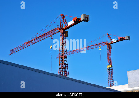 2 construction cranes against deep blue sky Stock Photo