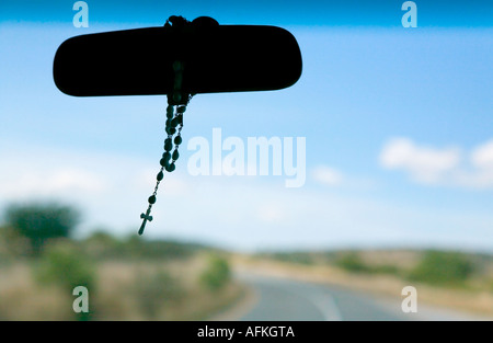 Rosary hanging from rear view mirror in taxi cab in Mexico Stock Photo