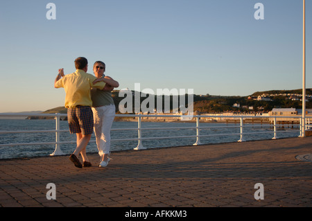 Middle -aged couple dancing in the evening on the promenade at Aberystwyth Ceredigion Wales UK Stock Photo