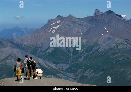 Hikers look out across the French Alps on the Ruillans Pass near La Grave, Haute-Alpes, France. Stock Photo