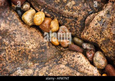 Stone pebbles fill a crack in a sandstone formation along the coastline of Lake Superior, Michigan Stock Photo