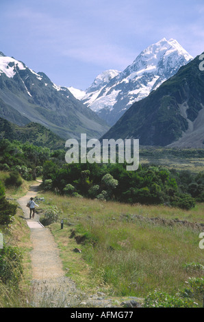 A tourist walking down one of the access tracks to Mt Cook or Mt Aoraki New Zealands tallest mountain Stock Photo