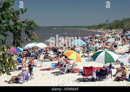 Beach scene with sunbathers and colorful umbrellas at Grand Beach Provincial Park on Lake Winnipeg Manitoba Canada Stock Photo