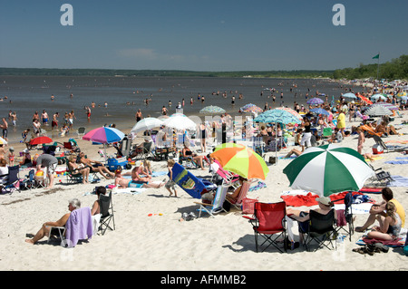 Beach scene with sunbathers and colorful umbrellas at Grand Beach Provincial Park on Lake Winnipeg Manitoba Canada Stock Photo