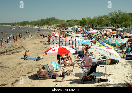 Beach scene with sunbathers and colorful umbrellas at Grand Beach Provincial Park on Lake Winnipeg Manitoba Canada Stock Photo