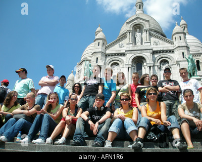 Group of adolescent students sitting on steps in front of Sacre Coeur Montmartre Paris France Stock Photo