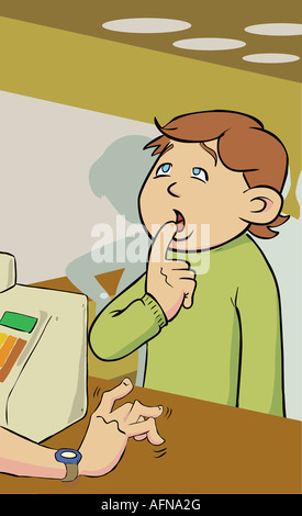 Boy with his finger on lips in front of a cash register Stock Photo