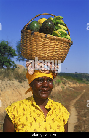 Black woman with basket of fruit balanced on head in Zimbabwe Stock Photo