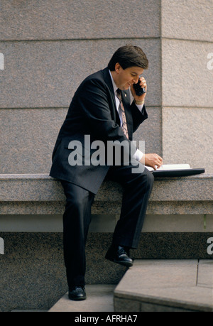 Man working, making a mobile phone call in the street. City of London, England. Circa 1995 1990s UK HOMER SYKES Stock Photo