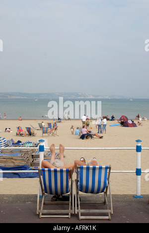 Retired couple relaxing in deckchairs in Weymouth resort in deckchairs Stock Photo