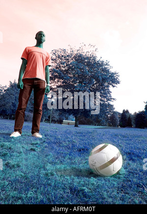 Young Black man playing football in the Park on a summers day Stock Photo