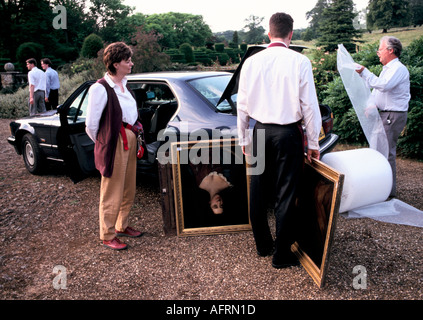 Country house sale auction Newnham Hall Northamptonshire 1994,  Christies auctioneer porters helping buyers take antiques to their cars. 1990s UK Stock Photo