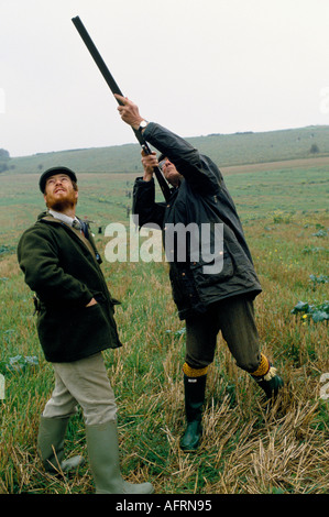 Partridge Shoot, Gurston Down, Wiltshire 2000s. Loader and shooter,  shooting party men dressed in traditional shooting country clothes. Private shoot Stock Photo