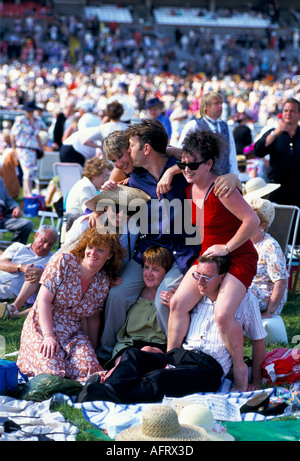 Best friends young adults going horse racing having fun, bonding  A day at the races Royal Ascot Berkshire 1980s UK HOMER SYKES Stock Photo