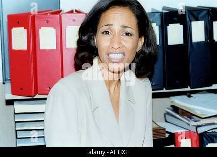 Young woman with files in background, close up, portrait Stock Photo
