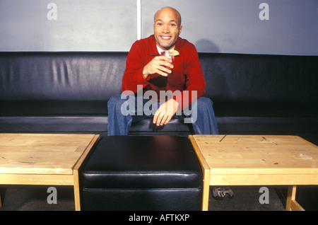 Young man having drink in bar, portrait Stock Photo