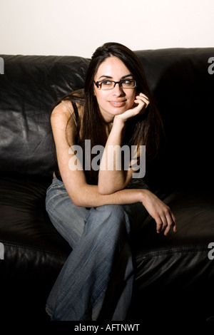 Young woman sitting on couch Stock Photo