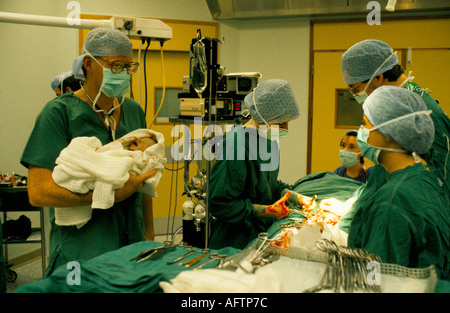 NHS 1980s Doctor Phil Hammond holding a new born baby by Caesarean section at the Royal United Hospital Bath. Somerset, England 1988 1980s UK Stock Photo