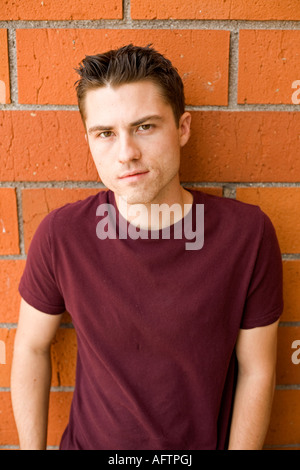 Young man leaning against wall, portrait Stock Photo