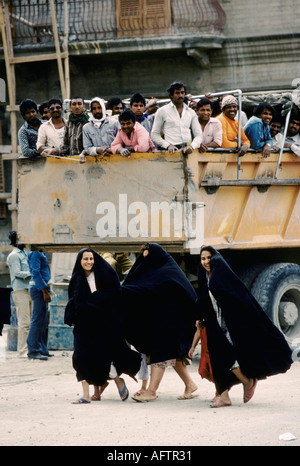 Baghdad 1980s Construction workers leave building site at the end of the day, a group of young women laughing and smiling.happy Iraq 1984 HOMER SYKES Stock Photo