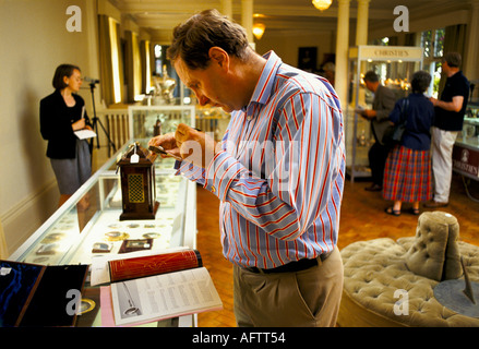 Country house auction hose sale at Newnham Hall Northamptonshire 1994, dealer examining antique that's for sale 1990s UK  HOMER SYKES Stock Photo