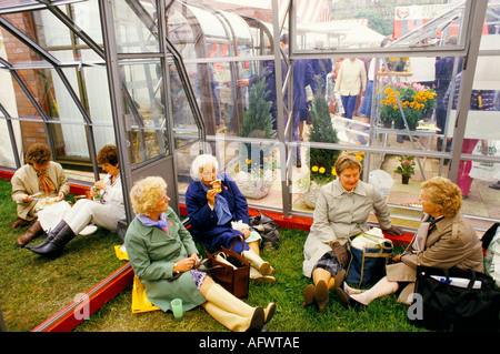 Chelsea Flower Show London 1980s.UK Woman tired out resting after  day. They are in an exhibition greenhouse 1984 HOMER SYKES Stock Photo