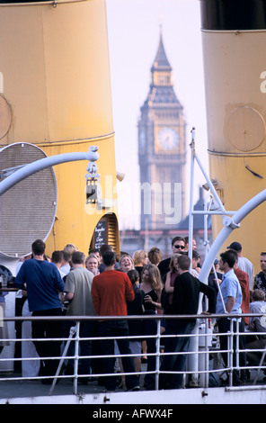 River boat bar restaurant on the River Thames Big Ben in background Westminster. London. After work Londoners enjoy a drink 1990s UK HOMER SYKES Stock Photo