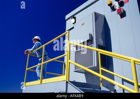 construction worker at railing at industrial plant Stock Photo