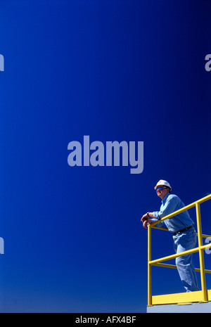 construction worker at railing at industrail plant Stock Photo