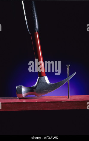 Leverage,  Hammer pulling nail from board Stock Photo
