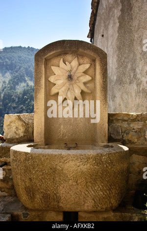 Public stone drinking water fountain in the mountain village of Bairols, Alpes Maritimes, France Stock Photo