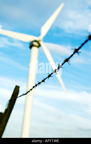 Old broken barbed wire fence in front of gleaming new wind turbine,Coal Clough,Burnley,Lancashire,UK Stock Photo