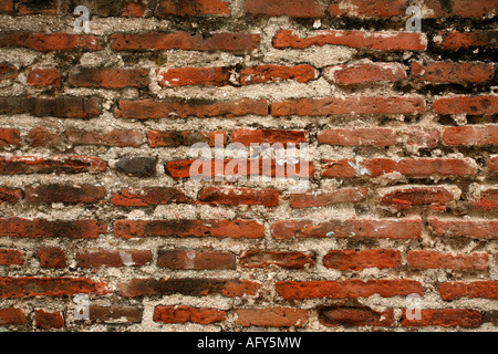 Old damaged wall made of stones and bricks for use as a background. Stock Photo