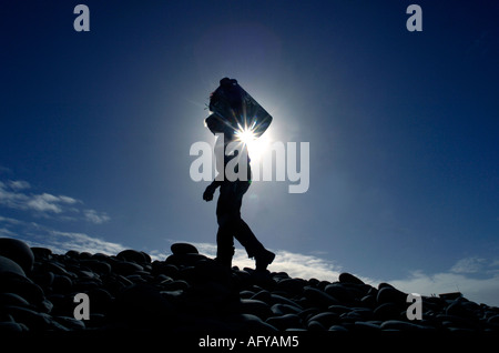 An active tidy beach campaigner collecting rubbish at Westward Ho! pebble beach  Devon UK Stock Photo