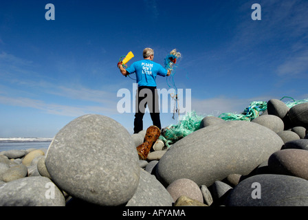 active tidy beach campaigner Les Garland collecting rubbish at Westward Ho! pebble beach North Devon UK Stock Photo