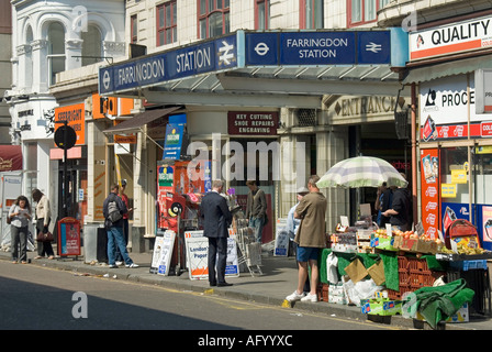 Congested pavement street scene traders & pedestrians around the entrance to Farringdon tube station in Cowcross Street Central London England UK Stock Photo