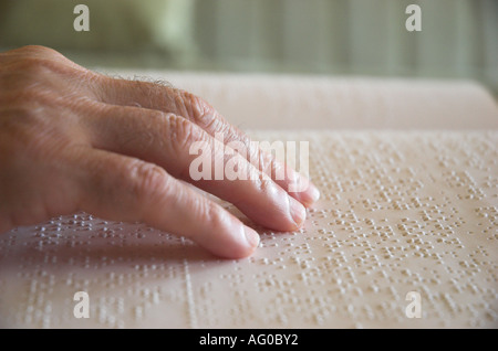 Persons hand reading book in braille close up Stock Photo