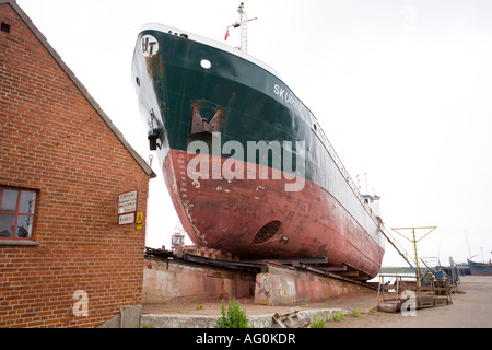 Skurin at Dry Dock A large old ocean freighter its bow thrusters and anchors showing pulled up in drydock Stock Photo