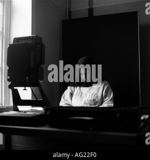 A young asylum seeker from Somalia waits to be photographed for her identification card at Barking Town Hall, Essex, London, UK. Stock Photo