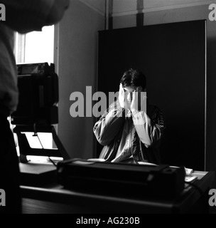 A young asylum seeker waits to be photographed for his identification card at Barking Town Hall, Essex, London, UK. 1999. Stock Photo