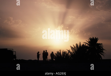 Algeria Timimoun Tourists chatting in Sahara desert at sunset Stock Photo