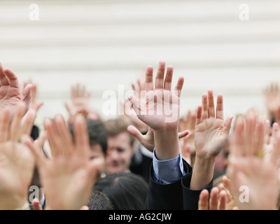 Crowd of people raising hands, focus on hands Stock Photo