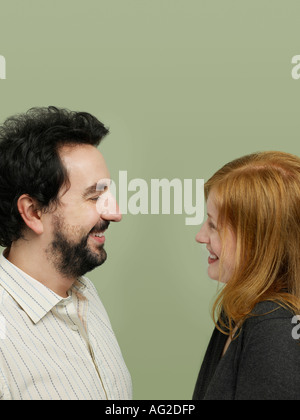 Mid adult woman and man looking in eyes, profile Stock Photo