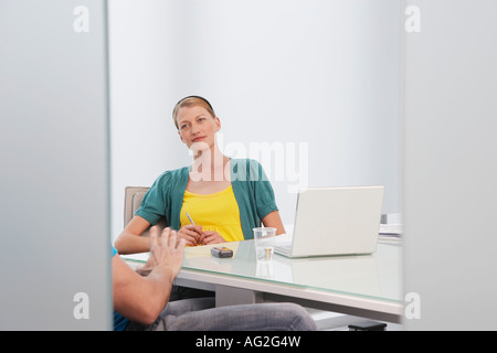Woman talking to man (mid section) in office Stock Photo