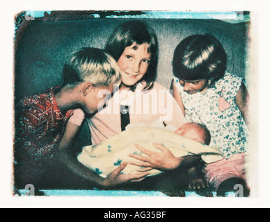 Polaroid transfer portrait of siblings holding new baby circa 1960s Stock Photo