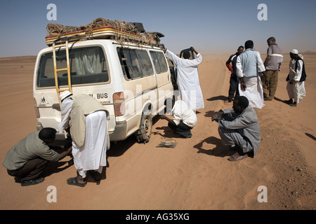 Changing a flat tire in the Nubian Desert, northern Sudan Stock Photo