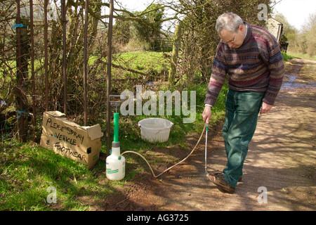 Journalist Matthew Engel disinfecting his shoes at entrance to farm during 2001 foot and mouth outbreak Herefordshire England UK Stock Photo