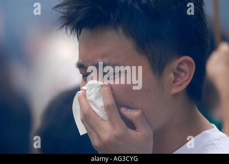 Young Chinese man covering his mouth with handkerchief  China Stock Photo