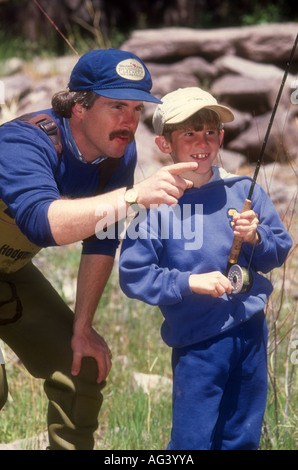 Father teaches fly fishing to young son. Green River, UT. USA Stock Photo