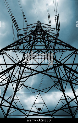 Electricity Pylon silhouetted against a stormy sky looking up. Low viewpoint. Stock Photo